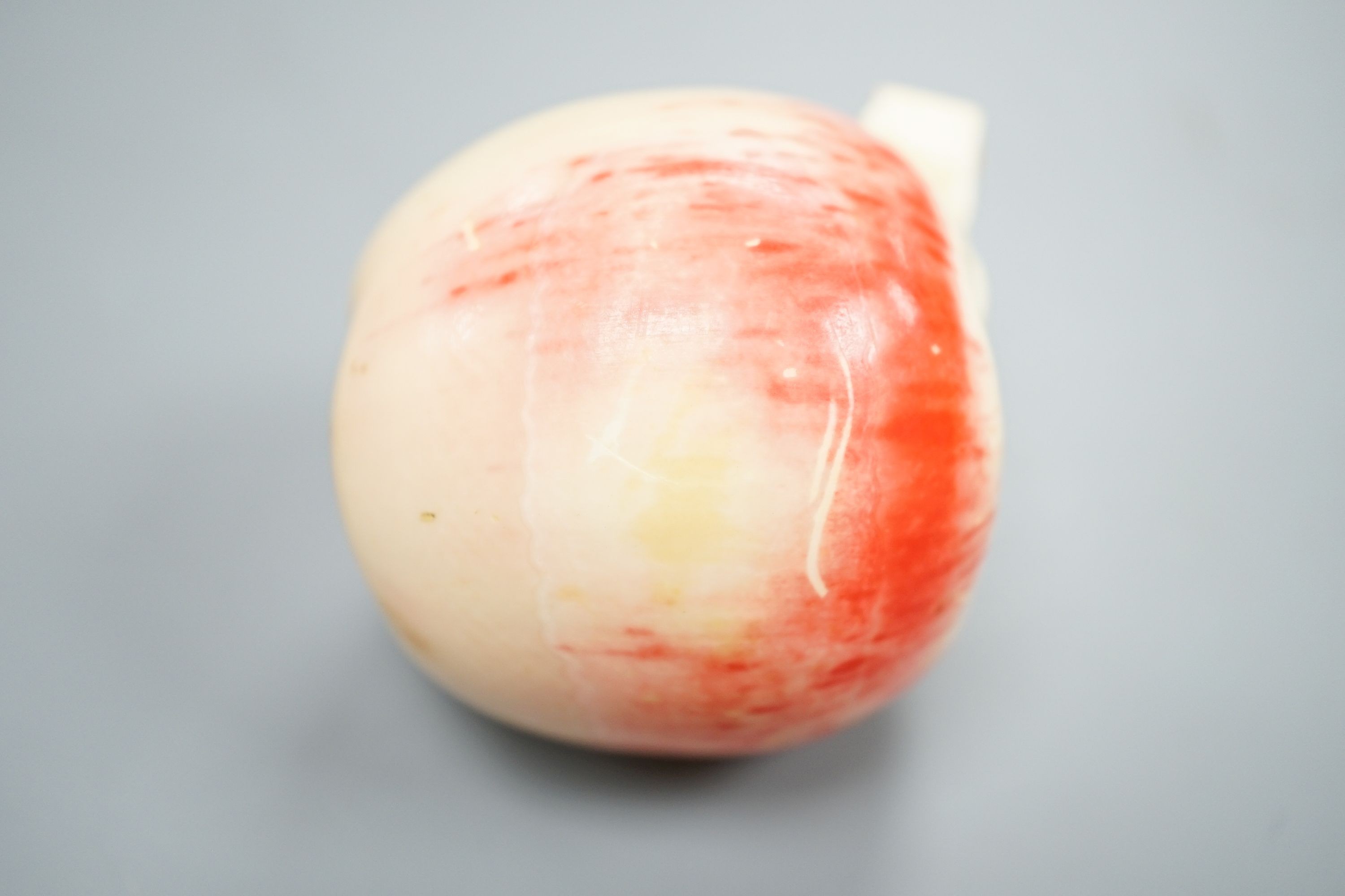 A Japanese carved ivory model of a partially peeled apple, c.1900, 5cm
